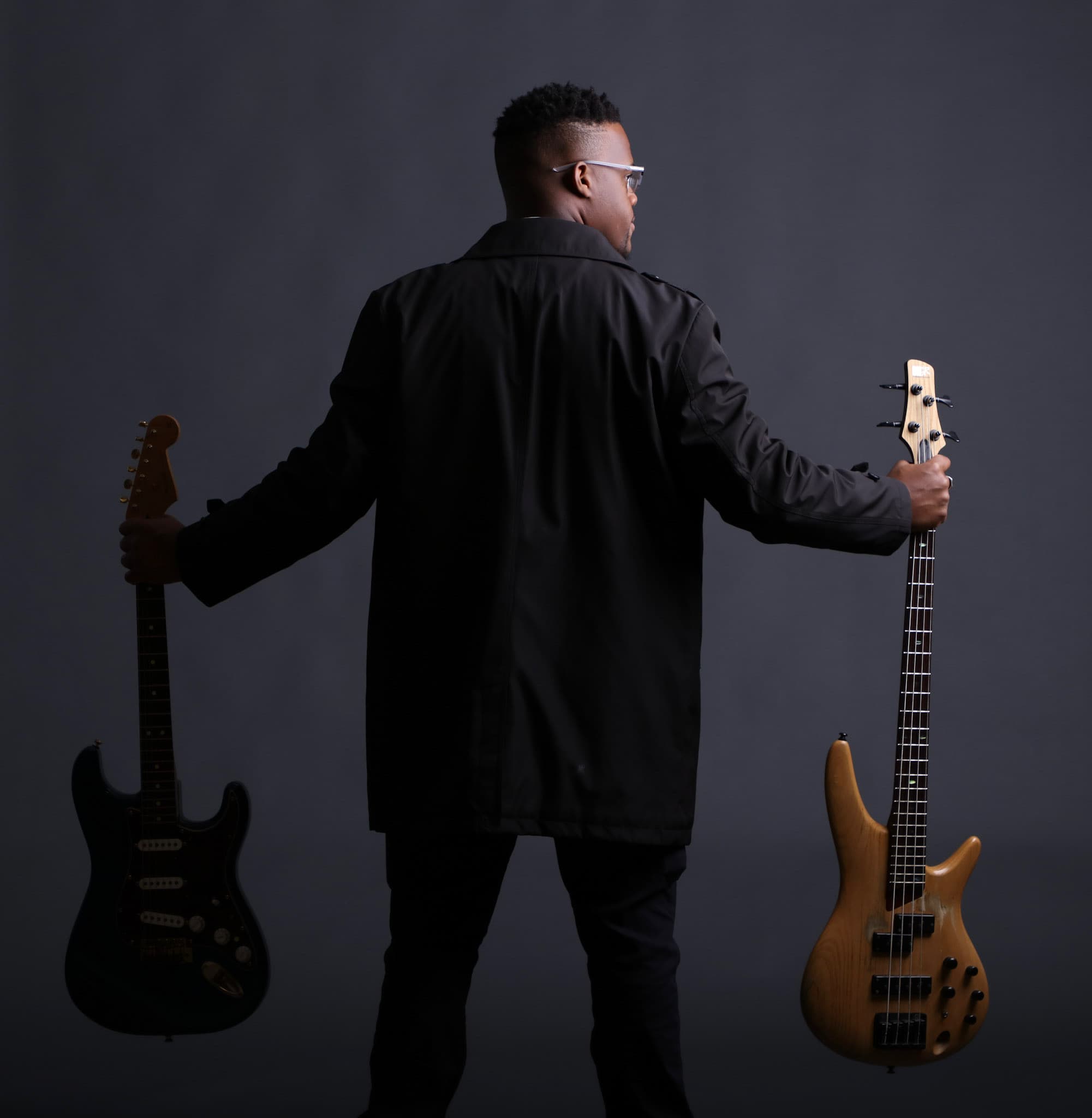 JKelly Music holding electric and bass guitars
