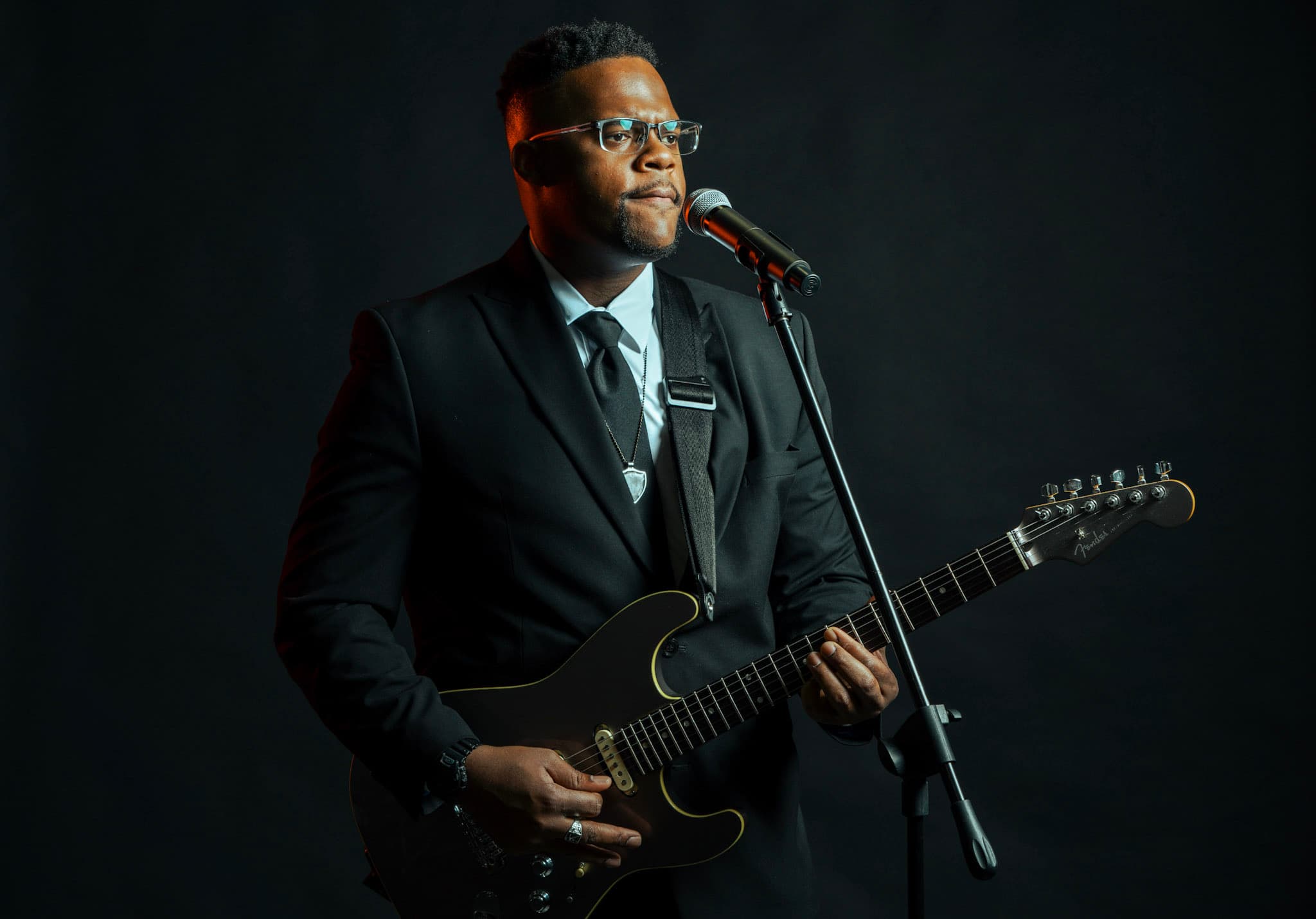 JKelly Music performing with electric guitar and microphone